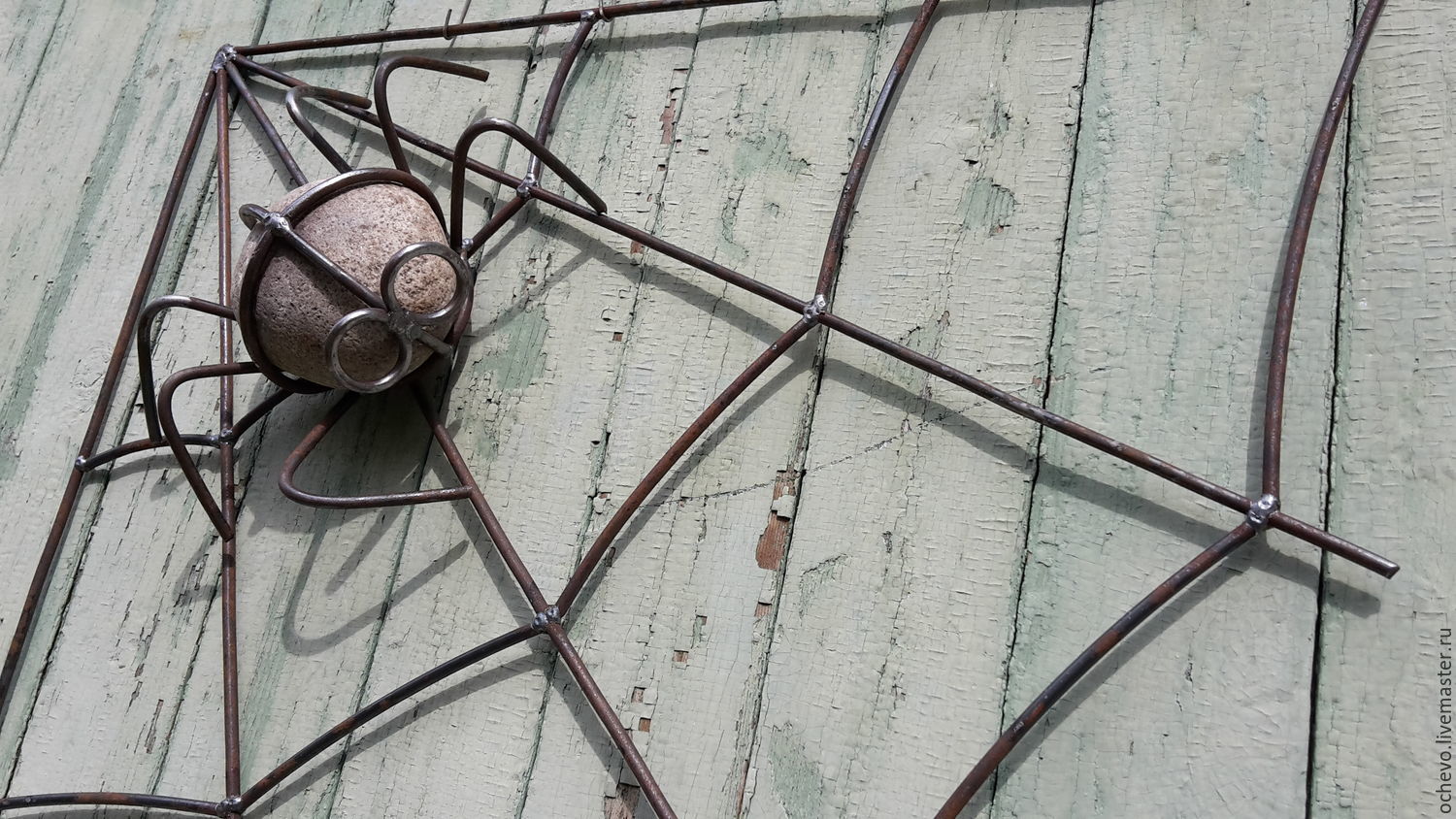 Паук с паутиной из металла во дворе
