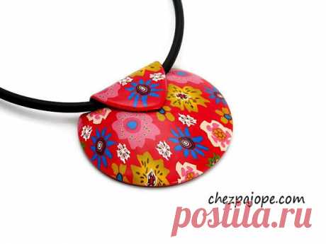 Red flower pendant necklace - polymer clay Short necklace composed of a red domed pendant in the shape of a shell.  Entirely made by me, this pendant has been baked, sanded and glossed to bring it softness and shine. No varnish.  Flowery motifs are taken in the mass (no paint or applications)  Black back, textured imitation leather.  Mounted on wired cable set with a black rubber cord.  Length: 42 cm.  Extension chain of 4 cm.  Necklace very very light to wear.