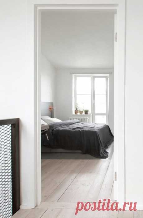 Спальня в стиле лофт с белыми стенами и светлым паркетным полом