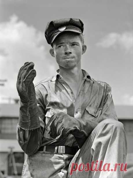 Throwing Shade: 1942 July 1942. "Decatur, Alabama. Ingalls Shipbuilding Company. Construction of ocean-going barges for the U.S. Army. Welder's helper shading his eyes from the welder's torch." Acetate negative by Jack Delano for the Office of War Information.