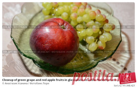 Closeup of green grape and red apple fruits in glass plate on table. Healthy eating lifestyle. Стоковое фото, фотограф Анастасия Усанина / Фотобанк Лори