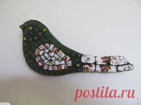 Mosaic Bird - Green with Crockery wing and tail Mosaic Green with Crockery Bird wall hanging. Made by myself using glass tiles, millefiori glass beads and a crockery wing. Bird has been grouted and sealed. The back and sides are painted black. The base is MDF and is best to be hung inside. Size is 25cm across widest point x 11cm in length.