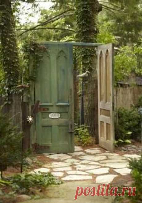 Create a "secret garden" by replacing your garden gate with oversized doors! | Living the Country Life | https://www.livingthecountrylife.com/homes-acreages/country-homes/18-creative-ways-repurpose-vintage-doors/