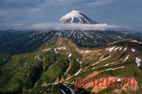 Окутанный облаками и очень красивый вулкан, но фотограф не подписал, где и какой именно. Нам кажется, что Вилючинский на Камчатке. Вы как думаете? Снимал Сергей Соннов: nat-geo.ru/community/user/223352