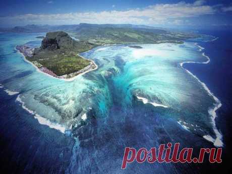 Подводный водопад, Маврикий. Эта великолепная иллюзия подводного водопада находится около полуострова Леморн Брабант, на острове Маврикий. Такой необычный природный ландшафт сформировался в результате стока песка и иловых отложений. Маврикий окружен коралловым рифом. Рельеф, образованный рифом, подводные течения, иловые отложения, движущийся под действием подводных течений песок создают иллюзию подводного водопада. Также способствует иллюзии прозрачность воды в пределах кораллового рифа.