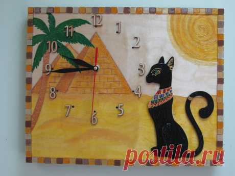 Настенные часы &quot;Египетская кошка&quot;
Настенные часы-картина изготовлены из березовой фанеры 0,9 см толщиной, роспись акрилом, кварцевый часовой механизм, сверху покрыты лаком, рамка выложена блестящей мозаикой. Размер 34*28 см
Цена 1800 руб.