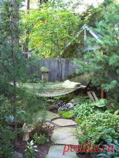 Outdoor Rooms: making your entire yard a private paradise, take one corner and transform it into a secluded getaway. A redbud just behind the hammock enhances the effect.