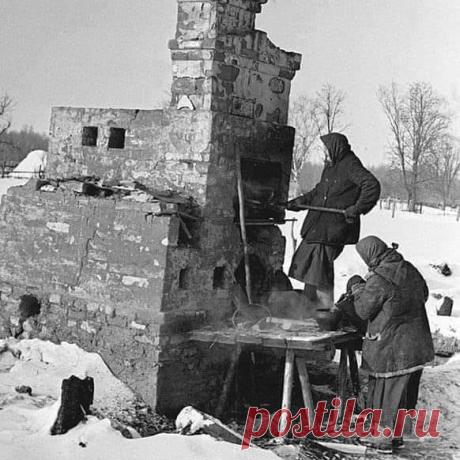 Январь 1942 г. Деревенские женщины готовят еду в сохранившейся печи. Такое фото войны. Фотограф Леонид Доренский.