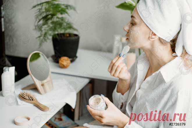 молодая женщина в белом халате, охлаждающая в спальне и делающая когтистую маску для лица возле зеркала девушка, делающая косметические процедуры и расслабляющая дома утренний уход за кожей рутина красоты, уход за собой... - стоковое фото | Crushpixel