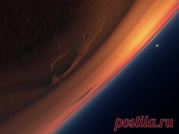 Марс. Южный вал кратера Холдена. Лучи солнца, вырываются из-под остроконечных пород, подсвечивая прозрачные облака в форме звезды / Интересный космос