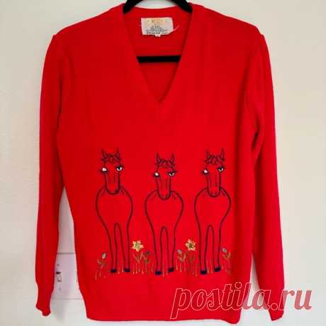 Vintage 1970s Embroidered Novelty Winking Horses Sweater Red Acrylic V-Neck Shop jessmcl93's closet or find the perfect look from millions of stylists. Fast shipping and buyer protection. This sweater is SO CUTE.

Embroidered horses wink at you on the front, and on the back you have their rear ends. 

Red v-neck sweater, 100% acrylic. Made in Taiwan, Republic of China - this puts the sweater’s manufacture date in the early 1970s or late 1960s. 
Brand: Shirlee Designs 

Thi...