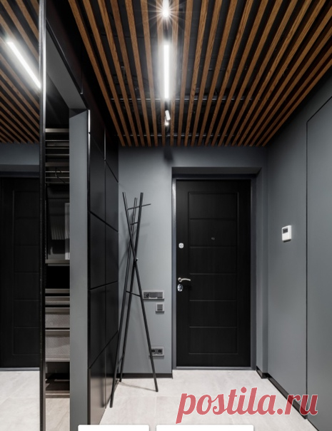 Прихожая с серыми стенами, одностворчатой входной дверью, черной входной дверью, бежевым полом и деревянным потолком - смотрится стильно.