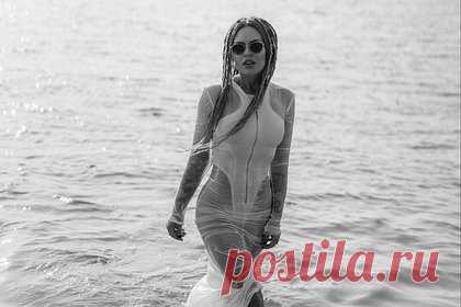 Рита Дакота снялась в прозрачном платье в воде. Певица Рита Дакота снялась в откровенном наряде во время отдыха в Дубае. На размещенных кадрах 33-летняя поп-исполнительница предстала в прозрачном платье длины макси на молнии. Она надела изделие поверх слитного белого купальника с глубокими вырезами в районе бедер. При этом знаменитость заплела волосы в дреды.