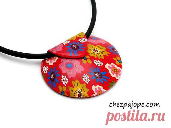 Red flower pendant necklace - polymer clay Short necklace composed of a red domed pendant in the shape of a shell.  Entirely made by me, this pendant has been baked, sanded and glossed to bring it softness and shine. No varnish.  Flowery motifs are taken in the mass (no paint or applications)  Black back, textured imitation leather.  Mounted on wired cable set with a black rubber cord.  Length: 42 cm.  Extension chain of 4 cm.  Necklace very very light to wear.