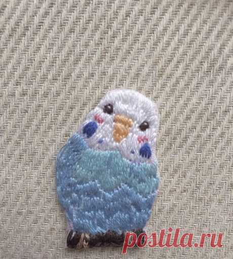 a small blue and white bird sitting on top of a beige cloth covered tablecloth