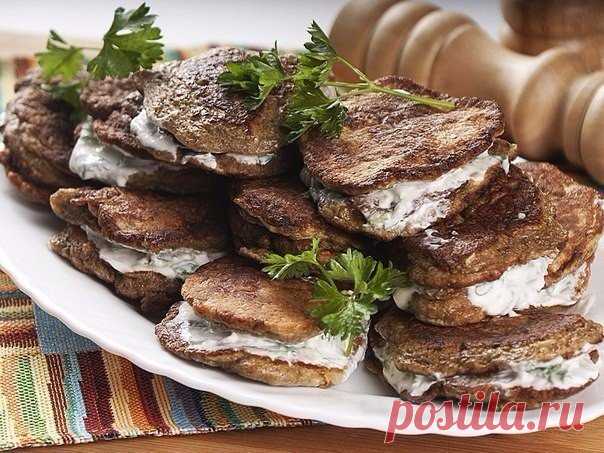 Печеночные оладьи в сметанном соусе

Печёнка – продукт, который любят далеко не все. Аппетитные печёночные оладьи в нежном сметанном соусе помогут вам раз и навсегда изменить представление о печёнке, если вы её ещё не полюбили.

Ингредиенты:
- мука - 5 столовых ложек,
- яйца - 3 шт.
- говяжья или свиная печень - 500 г,
- 1 чайная ложка соды (гашёной уксусом),
- чеснок - 3-4 зубчика,
- сметана,
- молоко - 50 г,
- петрушка или укроп,
- соль, перец по вкусу,
- оливковое масло...