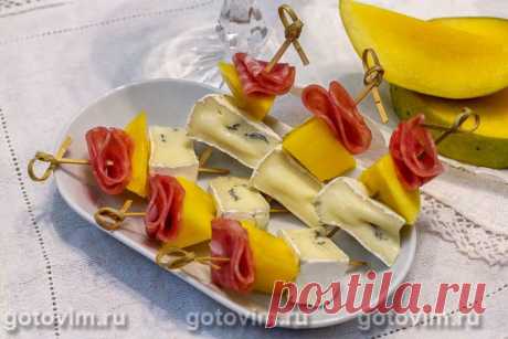 Канапе из камбоцолы,манго и копченой колбасы. Рецепт с фото У камбоцолы (или камбозолы) мягкий сливочный вкус и при этом присутствует нотка, характерная для сыров с плесенью. Причем это мягкий сыр особенный - сверху у него белая плесень, а внутри - вкрапления голубой. Этот сыр отлично сочетается не только с фруктами, но и сыровяленым мясом. Подойдет хоть хамон, хоть, как в нашем случае, готовая нарезка сольчичона. Канапе готовится быстро, выглядит аппетитно и это просто вк...