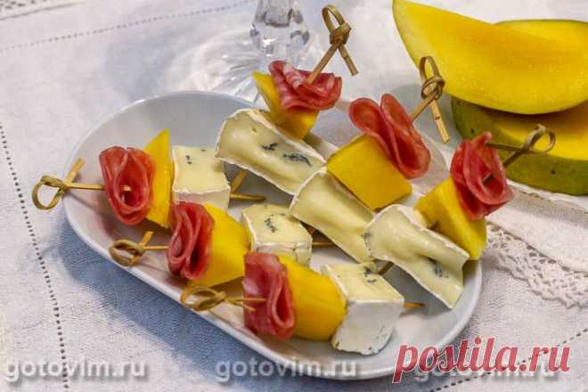 Канапе из камбоцолы,манго и копченой колбасы. Рецепт с фото У камбоцолы (или камбозолы) мягкий сливочный вкус и при этом присутствует нотка, характерная для сыров с плесенью. Причем это мягкий сыр особенный - сверху у него белая плесень, а внутри - вкрапления голубой. Этот сыр отлично сочетается не только с фруктами, но и сыровяленым мясом. Подойдет хоть хамон, хоть, как в нашем случае, готовая нарезка сольчичона. Канапе готовится быстро, выглядит аппетитно и это просто вк...