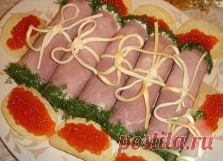 Мясные завитки на Новогодний стол
Ингредиенты:
-сыр
-яйца
-чеснок
-майонез
-копченый сыр
-укроп
-ветчина
Сыр и отварные яйца потереть на крупной терке, добавить измельченный чеснок, майонез и хорошо перемешать.
Ветчину порезать тонкими пластами.
На край каждого кусочка ветчины положить немного начинки и свернуть свиток.
Перевязать свитки полосками сыра. Это копченый сыр типа "Чечел", продается скрученный в косу.
Обмакнуть края свитков в майонез, а затем в мелко порубленный укроп.
Можно подават