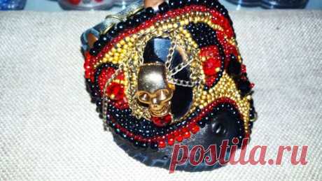 А вот это уже немного интереснее: Весёлый Роджер повис на пьедестале из чёрного агата, на фоне мягкой натуральной кожи в окружении бисера и хрусталя!