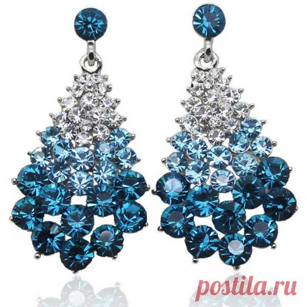Посмотрите на эти роскошные серьги. Форма ничего не напоминает? Да это же настоящие новогодние елочки. Дизайнеры очень удачно скомбинировали кристаллы нейтрального цвета и голубого, а универсальная классическая треугольная форма этих украшений делает сережки по-настоящему универсальным аксессуаром, который подойдет под белое, синее или голубое вечернее или повседневное платье.