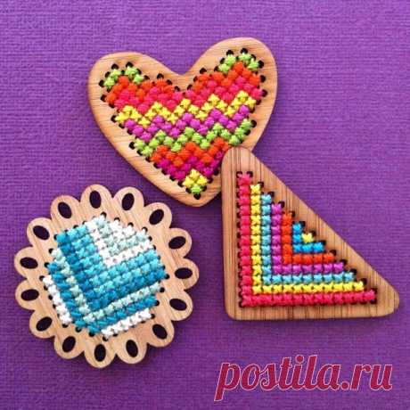 three wooden heart shaped magnets with beaded designs on purple background, including one in the shape of a heart