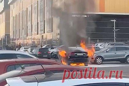 Горящий около ТЦ в Москве автомобиль попал на видео. В Москве около торгового центра (ТЦ) загорелся легковой автомобиль. Видеоролик с горящей легковушкой опубликовали «Известия». На кадрах виден охваченный пламенем автомобиль, стоящий на парковке в окружении других машин. Некоторые из транспортных средств стоят почти вплотную.