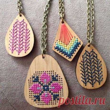 four wooden necklaces with different designs on them