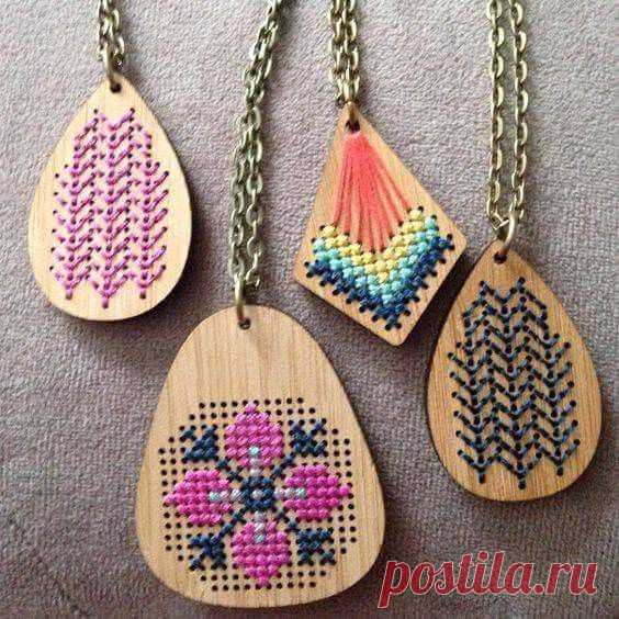 four wooden necklaces with different designs on them