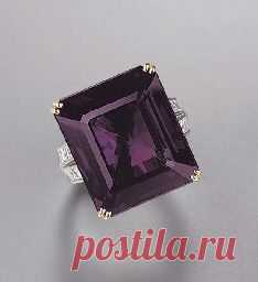 AN ALEXANDRITE AND DIAMOND RING The rectangular-cut alexandrite weighing 24.25 carats to the square-cut diamond bifurcated shoulders, mounted in platinum and 18k gold
