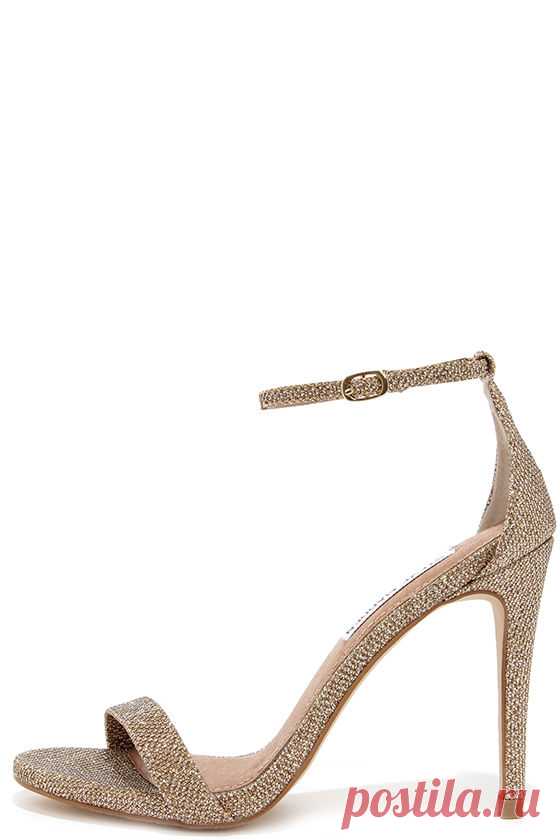 Steve Madden Stecy Gold Fabric Ankle Strap Heels Either with your beau or on your own, wherever you go the Steve Madden Stecy Gold Fabric Ankle Strap Heels will step up your style! These chic high heel sandals are made from glittery gold fabric, with an on-trend single toe band and an adjustable ankle strap (with gold buckle) anchored by a slender heel cup.