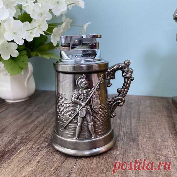 Vintage Tankard Table Lighter A great vintage tankard table lighter.  This figural table lighter features a pewter finished base with ornate handle.  On one side there is an embossed knight in armor with weapon and shield guarding a castle, and on the other a knight with ornate scroll work.  The lighter portion is removal for filling.  Marked Japan, labeled JJJ Japan, Gas.  The mid century lighter is in very good condition with evidence of use, no dings or dents.  The tabl...