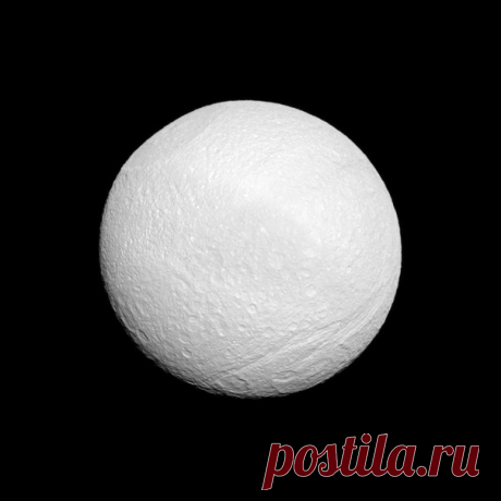 Тефия. Пятый по величине спутник Сатурна сплошь покрыт кратерами и каньонами. В частности, справа внизу на фото виден грандиозный каньон Итака (Ithacus Chasma) протяженностью около 1000 км! А вверху мы видим гигантский кратер Одиссей (Odysseus Crater) едва ли не в половину поперечника Тефии. Этот замечательный снимок получен 14 сентября 2011 года зондом &quot;Кассини&quot;. / Интересный космос
