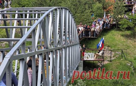 Первый в КЧР стеклянный мост на высоте 30 м открыли в День России. Первыми по нему прошлись глава администрации Малокарачаевского района КЧР Рамазан Байрамуков, старейшины и гости