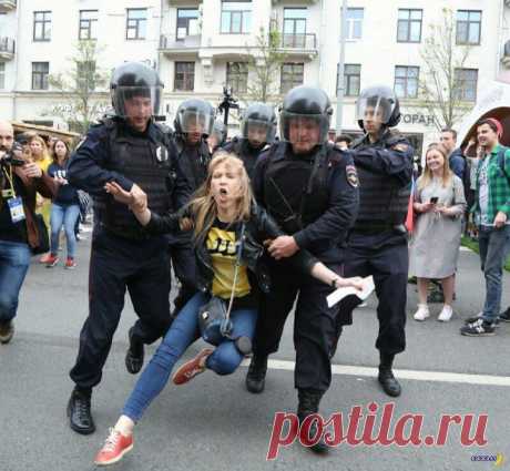 История одного протеста | Чёрт побери Вот эта фотография облетела весь мир. Красивую блондинку во время акции протеста российской оппозиции волокут куда-то сотрудники ОМОН, а она красиво кричит, волосы развиваются, ногами сучит. Чуть ли не символ революции. Но обратите внимание, справа на заднем плане люди смотрят и смеются. Что происходит и в чем подвох? Во-первых, дамочку опознали, это некая Мария Баронова, известная российская оппозиционерка. Любит красиво протестовать ...