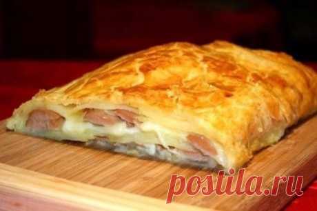 ШТРУДЕЛЬ С КАРТОФЕЛЕМ И СОСИСКАМИ 
Ингредиенты: 
- Тесто слоеное дрожжевое — 1 шт. 
- Сосиски — 6 шт. 
- Картофель — 3 шт. 
- Сыр "Голландский" — 150 г 
- Желток яичный — 1 шт. 
- Любимые специи — по вкусу 
Приготовление: 
1. Отварить картошку в мундире в подсоленной воде в течение 10-15 минут. Затем почистить картошку и порезать тонкими ломтиками. Разрезать сосиски пополам. 
2. Раскатать пласт слоенного теста размером 35x30 см и выложить его на смазанный противень или на силиконовый коврик.