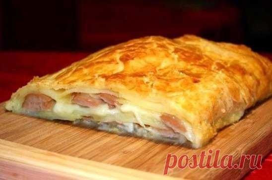 ШТРУДЕЛЬ С КАРТОФЕЛЕМ И СОСИСКАМИ 
Ингредиенты: 
- Тесто слоеное дрожжевое — 1 шт. 
- Сосиски — 6 шт. 
- Картофель — 3 шт. 
- Сыр 