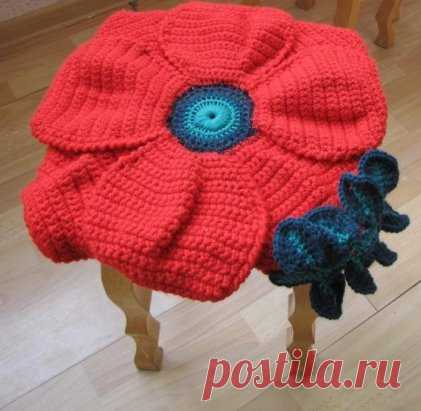 Оригинальная подушка-сидушка в виде цветка
Вязание крючком 
Материалы: 
на одну сидушку необходимо около 3 мотков пряжи Ализе Суперлана Макси(темно-красная) или ЯрнАрт Мерино Балки(алая) , немного Семеновской (темно-зеленая), совсем немного хлопока (светло-зеленый) и фактурной пряжи «Кристалл»(черная).
1р Светло-зеленой пряжей крючком №4 наберите 4возд.п. и сомкните в кольцо 
2р в центр кольца 30сбн 
3р Переход на темно-зеленую пряжу 30сбн 
4р Переход на черную пряжу «Кристалл» 30сбн
Далее иде