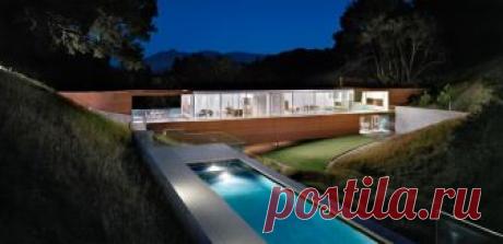 Дом-мост в Калифорнии | Блог "Частная архитектура" Дом-мост (Bridge House) в США от Stanley Saitowitz Natoma Architects. Дом, стоящий на 22-х стойках, мостом соединяет восточную и западную стороны небольшого ущелья. Стеклянная лента сверху открывает жилую часть верхнего уровня на северные холмы, стеклянные стены нижнего уровня ориентированы на южный благоустроенный ландшафт. Уже поржавевшие стальные отделочные листы особенно хороши в сочетании с осенним разноцветьем. На кр...