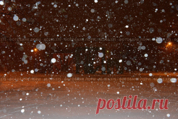 A snowy scene with a lot of snowflakes falling from the sky. The snow is covering the ground and the sky is dark. Парк имени 50-летия Октября в Москве ночью зимой. (2016 год) Редакционное фото, фотограф Ilaronsia / Фотобанк Лори