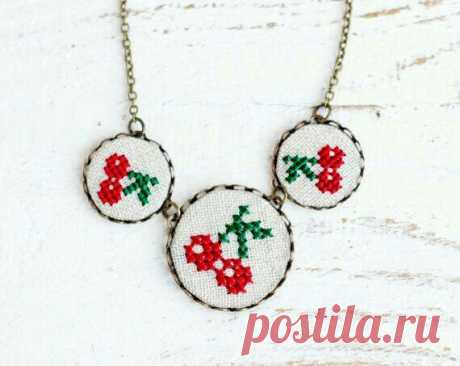 two cross stitch necklaces with cherries on them