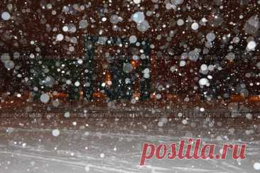 A snowstorm in progress, with snowflakes falling from the sky and covering the ground. The scene is dark and moody, with the snow creating a sense of isolation and stillness. Парк имени 50-… (2016 год) Редакционное фото, фотограф Ilaronsia / Фотобанк Лори