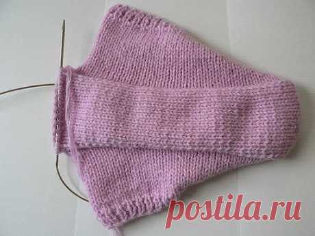 Тапочки-следочки

Набираем на круговые спицы 67 петель. Вяжем 4 ряда резинкой 1х1.
5-й ряд: 1-кромочная, 29-лицевых, накид, 7-лицевых, накид, 29-лицевых, 1-кромочная.
6-й ряд и все четные вяжем изнаночными петлями.
7-й ряд и все нечетные вяжем лицевыми, делая накиды до и после 7-ми центральных петель.
Вяжем до тех пор, пока на обеих сторонах от центральных 7-ми петель не будет по 40 петель (включая кромочные) = 20 рядов

Вывязываем подошву на 13-ти центральных петлях. Пров...