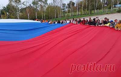 В Мелитополе в День воссоединения с РФ развернули триколор размером 1 300 кв. м. В развертывании флага приняли участие представители власти Запорожской области, молодежных организаций, НКО и певица Юлия Чичерина