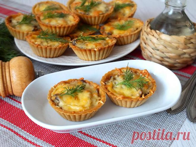Грибной жульен в тарталетках Грибной жульен в тарталетках - это аппетитная горячая закуска, которая порадует ваших близких. Грибы обжариваются с луком и сметаной, а затем выкладываются в тарталетки и посыпаются сыром. Блюдо готовится быстро и просто, а тарталетки заменяют кокотницы, что делает его ещё более удобным.