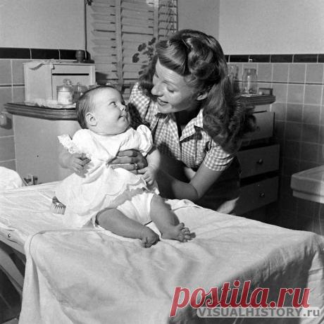 1945. Рита Хейворт дома с дочерью Ребеккой Уэллс: материнская сцена в интерьере кухни, повседневная нежность | VISUALHISTORY.ru