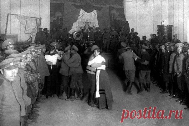 Солдатский бал. Две кухарки танцуют с солвремями, стоит рота, играет на сцене оркестр, вот такие они скромные балы у русских солдат. Первая мировая война, 1915 года. / Историческая справка