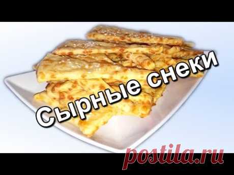 СЫРНЫЕ СНЕКИ - кулинарный рецепт
Мука пшеничная — 200 г
Сыр твердый — 150 г
Масло сливочное — 100 г
Молоко — 100 мл
Соль — 1\2 ч. л.
Разрыхлитель теста — 1\3 ч. л.
Цедра 1 лимона 
Кунжут (на посыпку)
