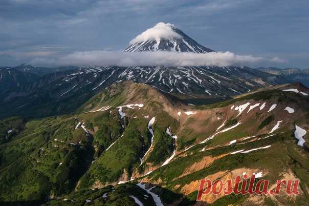 Окутанный облаками и очень красивый вулкан, но фотограф не подписал, где и какой именно. Нам кажется, что Вилючинский на Камчатке. Вы как думаете? Снимал Сергей Соннов: nat-geo.ru/community/user/223352