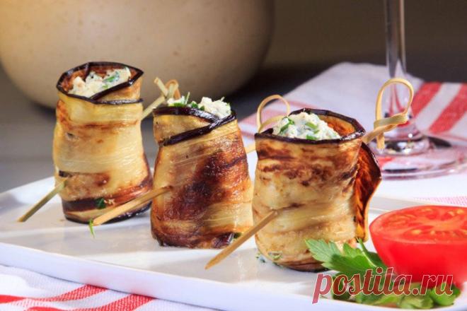 Рулетики из баклажанов Ингредиенты:Баклажаны (средние) — 1 шт.Творог — 200 гЧеснок — 1 зубчикСыр (твердый) — 50 гПетрушка — 1 пучокМасло растительное — для жаркиСоль — по вкусуПерец — по вкусуПриготовление:1. Баклажан нарез…